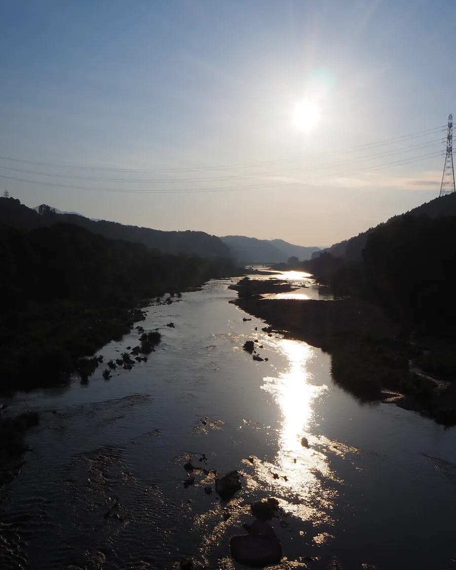 山々の間を流れる川と夕日の風景